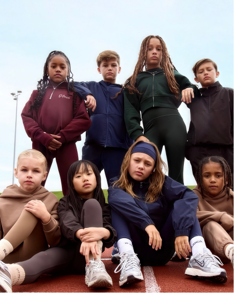A team of kids in Blanca Sport tracksuits posing on a running track